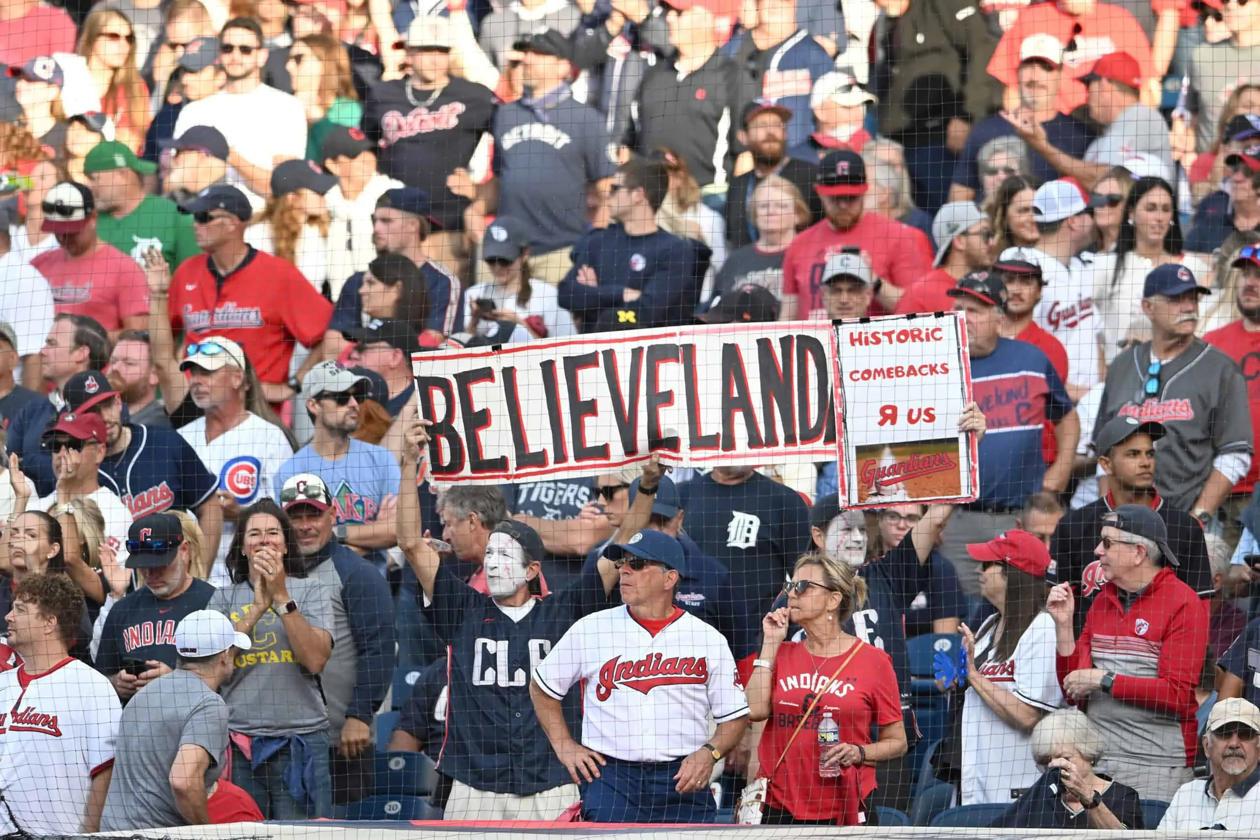 CLEVELAND, OHIO - OCTOBER 02: Cleveland Guardians fans cheer and hold a sign during the eighth inning Detroit Tigers in game three of the American League Wild Card Series at Progressive Field on October 02, 2025 in Cleveland, Ohio.