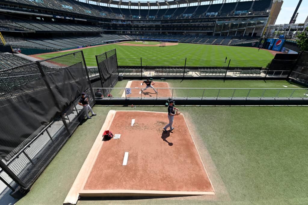 CLEVELAND, OHIO - JULY 06: Pitchers Carlos Carrasco #59 Logan Allen #54 of the Cleveland Indians throw in the bullpen during summer workouts at Progressive Field on July 06, 2020 in Cleveland, Ohio.