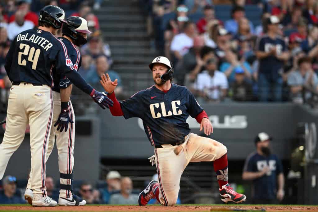 CLEVELAND, OHIO - MAY 29: Chase DeLauter #24, Daniel Schneemann #10 and Rhys Hoskins #8 of the Cleveland Guardians celebrate after DeLauter and Hoskins scored on a single hit by Angel Martínez during the first inning against the Boston Red Sox at Progressive Field on May 29, 2026 in Cleveland, Ohio.