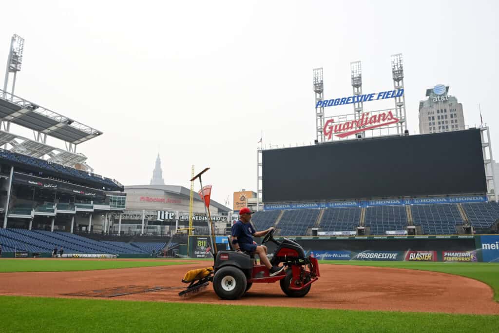 CLEVELAND, OHIO - JULY 17: A member of the Cleveland Guardians grounds crew rakes the field as the game against the Pittsburgh Pirates was postponed due to air quality at Progressive Field on July 17, 2026 in Cleveland, Ohio.