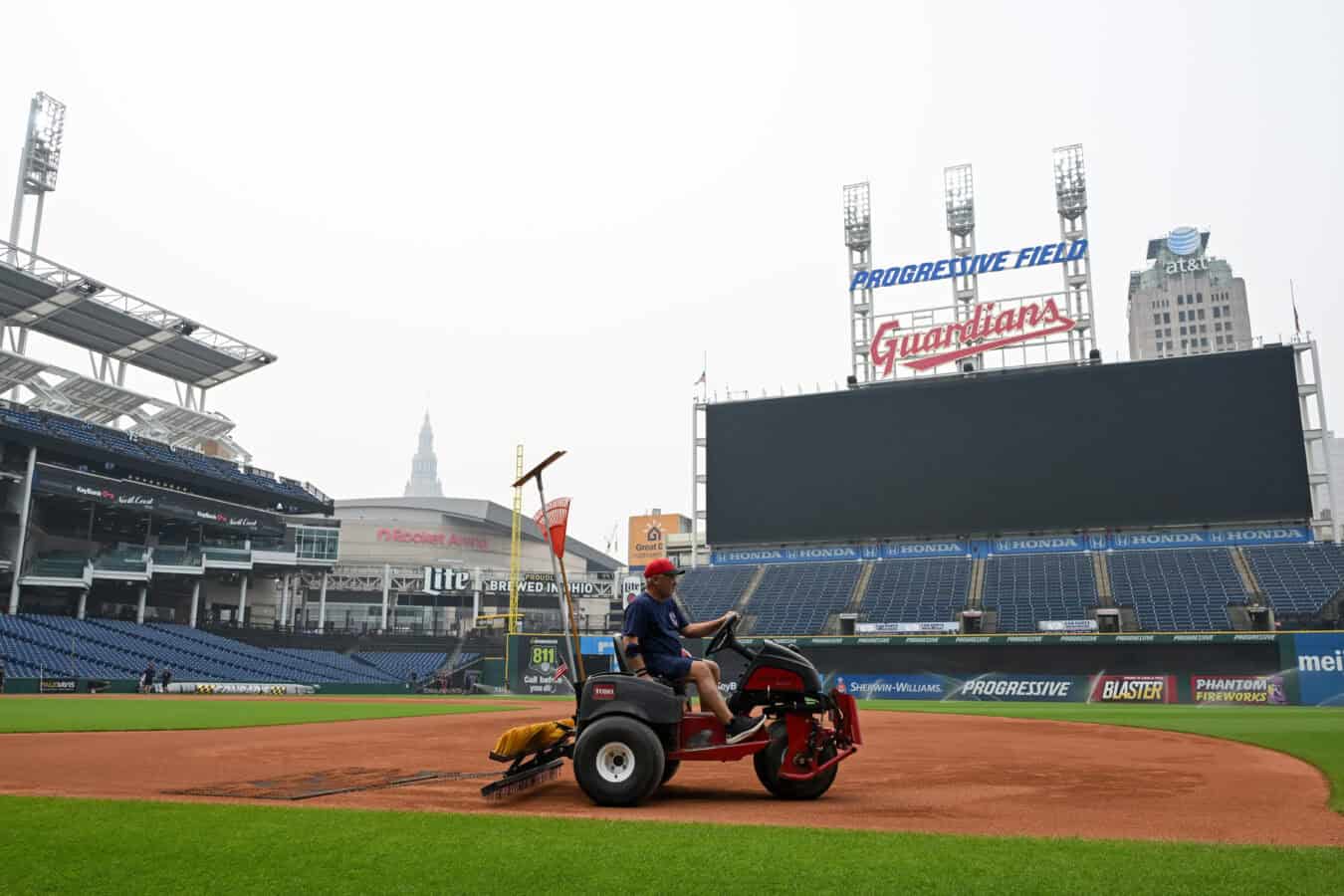 CLEVELAND, OHIO - JULY 17: A member of the Cleveland Guardians grounds crew rakes the field as the game against the Pittsburgh Pirates was postponed due to air quality at Progressive Field on July 17, 2026 in Cleveland, Ohio.