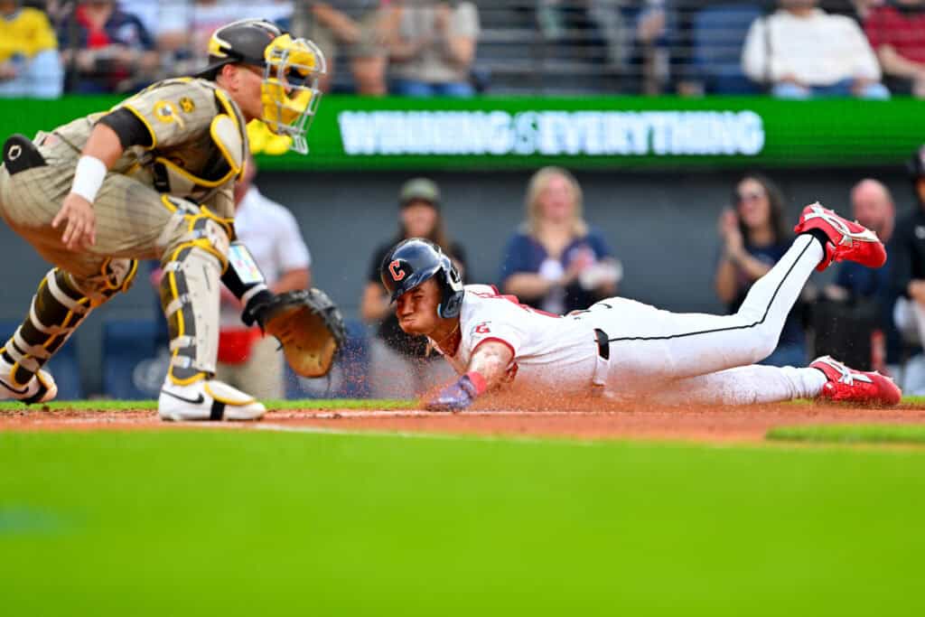 CLEVELAND, OHIO - AUGUST 15: Catcher Freddy Fermin #54 of the San Diego Padres waits for the throw as Angel Genao #17 of the Cleveland Guardians scores during the second inning at Progressive Field on August 15, 2026 in Cleveland, Ohio.