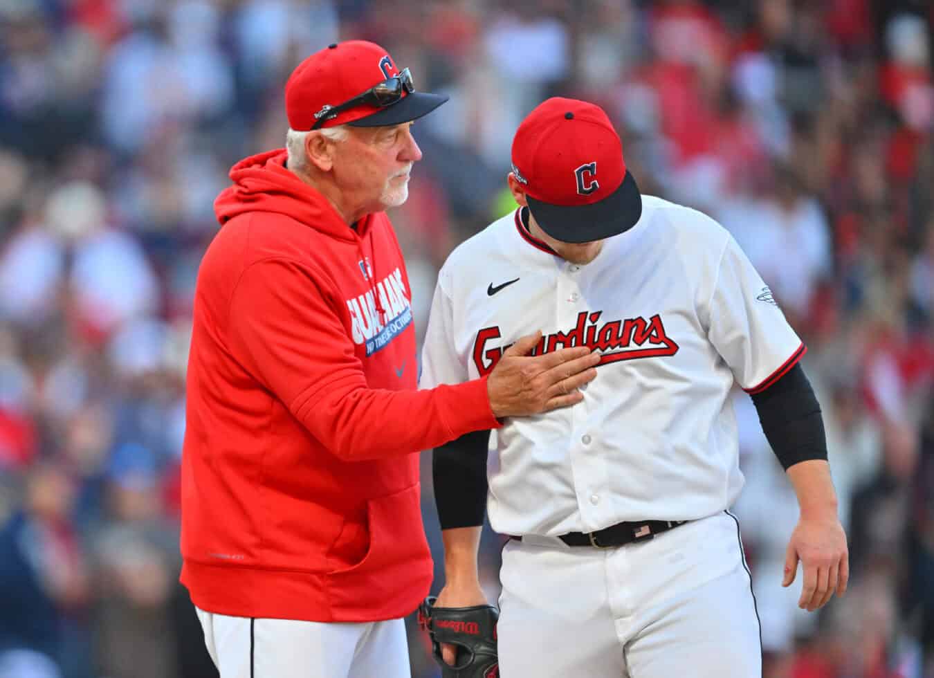 CLEVELAND, OHIO - OCTOBER 18: Parker Messick #77 (R) of the Cleveland Guardians is enouraged by pitching coach Carl Willis (L) after Messick walked in a run during the first inning against the Tampa Bay Rays in game five of the American League Championship Series at Progressive Field on October 18, 2026 in Cleveland, Ohio.