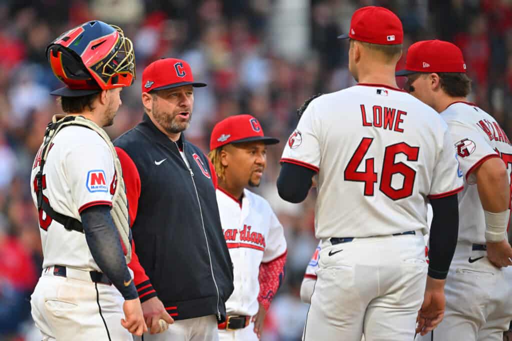 CLEVELAND, OHIO - OCTOBER 18: Manager Stephen Vogt of the Cleveland Guardians talks during a pitching change with Nathaniel Lowe #46 and Patrick Bailey #16 during the fourth inning against the Tampa Bay Rays in game five of the American League Championship Series at Progressive Field on October 18, 2026 in Cleveland, Ohio.