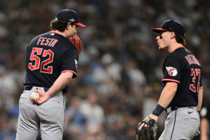 ST PETERSBURG, FLORIDA - OCTOBER 19: Matt Festa #52 of the Cleveland Guardians speaks to Travis Bazzana #37 of the Cleveland Guardians during the second inning against the Tampa Bay Rays in game six of the American League Championship Series at Tropicana Field on October 19, 2026 in St Petersburg, Florida.