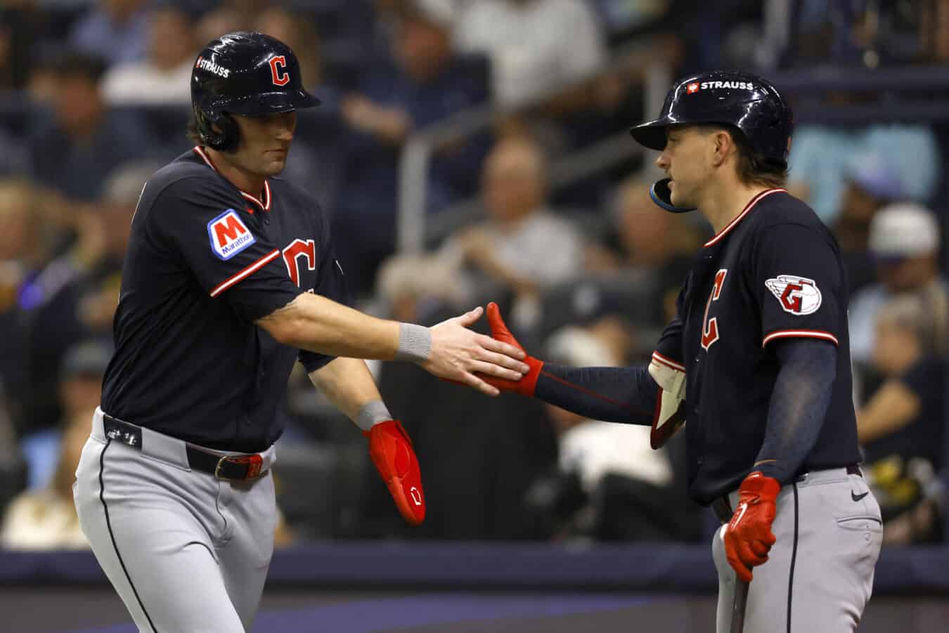 ST PETERSBURG, FLORIDA - OCTOBER 19: Chase DeLauter #24 of the Cleveland Guardians celebrates a run with Travis Bazzana #37 of the Cleveland Guardians during the sixth inning against the Tampa Bay Rays in game six of the American League Championship Series at Tropicana Field on October 19, 2026 in St Petersburg, Florida.